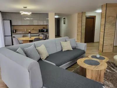 a living room with a blue couch and a table at Панорамен Пентхаус - Кабинков лифт - 3 спални in Bansko
