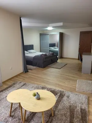 a bedroom with a bed and a table and a table sidx sidx sidx at Панорамен Пентхаус - Кабинков лифт - 3 спални in Bansko