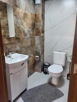 a bathroom with a toilet and a sink at Панорамен Пентхаус - Кабинков лифт - 3 спални in Bansko