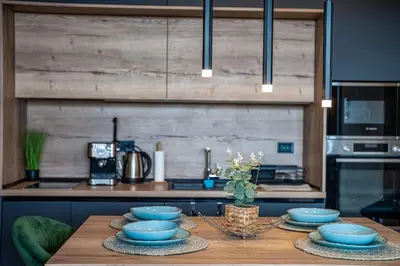 a kitchen with a wooden table with blue dishes on it at Getaway 2 Bedroom Dream Apartment - free parking in Bansko