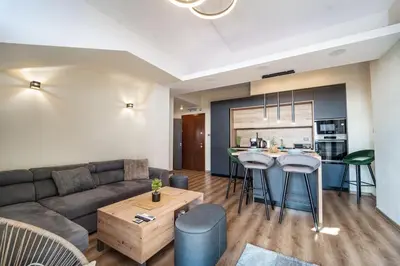 a living room with a couch and a kitchen at Getaway 2 Bedroom Dream Apartment - free parking in Bansko
