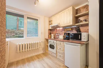 a small kitchen with wooden cabinets and a window at Stylish apartment, Top center! in Sofia