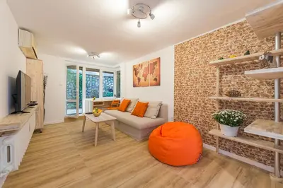 a living room with a couch and an orange ottoman at Stylish apartment, Top center! in Sofia