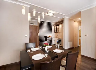 a dining room with a table and chairs and a kitchen at Apartments Carrera in Sofia