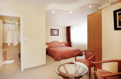 a room with a bed and a glass table at Apartments Carrera in Sofia