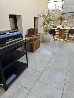 a patio with a stone floor with a fireplace at Newly Built Family Villa with a Hot Tub in Sopot