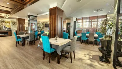 a dining room with tables and blue chairs at Belvedere Holiday Club 2Bedroom Apartment F201 in Bansko