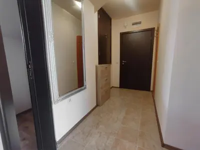a hallway with a mirror and a black door at 