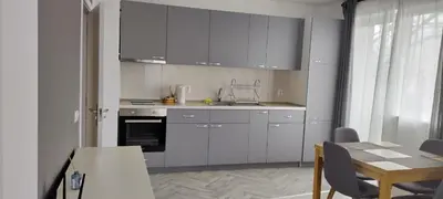 a kitchen with white cabinets and a table and a dining room at O pulse Sofia apartment in Sofia