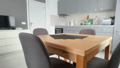 a kitchen with a wooden table and chairs at O pulse Sofia apartment in Sofia