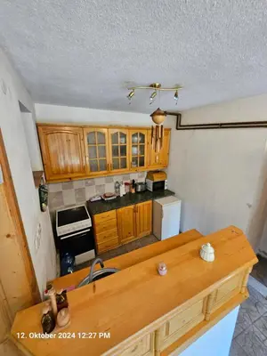 a kitchen with wooden cabinets and a counter top at Villa Dilyanka Stokite in Stoykite