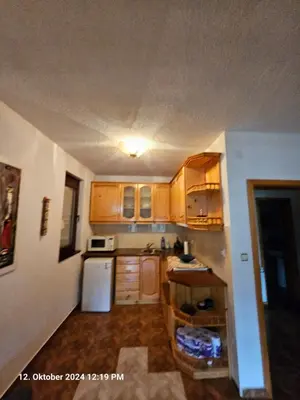 a kitchen with wooden cabinets and a white refrigerator at Villa Dilyanka Stokite in Stoykite