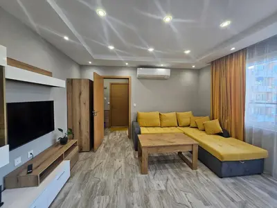 a living room with a couch and a tv at Boutique apartment yellow 1 in Plovdiv