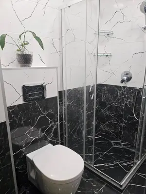 a bathroom with a toilet and a glass shower at Boutique apartment yellow 1 in Plovdiv