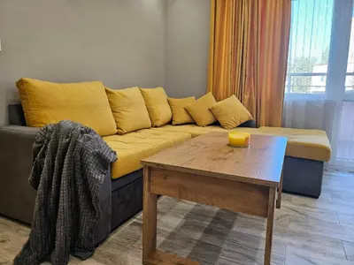a living room with a yellow couch and a table at Boutique apartment yellow 1 in Plovdiv