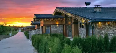 a house with a pathway next to a building with a sunset at Villa Pirin Golf in Bansko