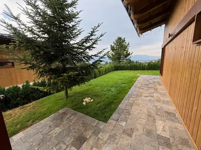 a garden with a tree in the middle of a yard at Villa Pirin Golf in Bansko