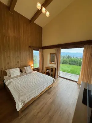 a bedroom with a large bed and a large window at Villa Pirin Golf in Bansko