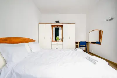 a bedroom with a white bed and a mirror at Large 2-BR Retreat, Walk to Sofias Top Spots in Sofia