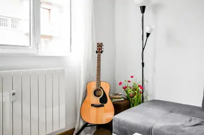 a guitar in a room with a bed and a window at Large 2-BR Retreat, Walk to Sofias Top Spots in Sofia
