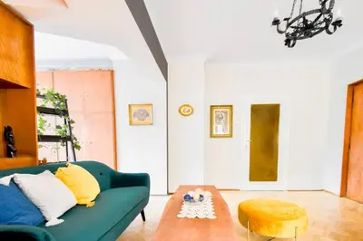 a living room with a green couch and a table at Creative 70s-Inspired Stay Center Parking in Sofia