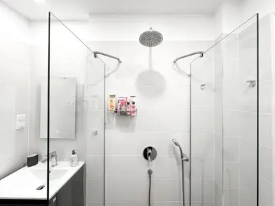 a white bathroom with a shower and a sink at Prime Spot - 2BR -15BTH - Next to Nevsky Church in Sofia