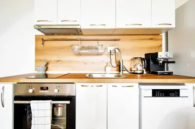 a kitchen with white cabinets and a sink at Work Friendly 2BR AC Terrace Str Parking in Sofia