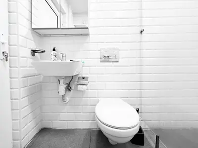 a white bathroom with a toilet and a sink at 1BDR Quiet Str Vitoshka Area AC in Sofia