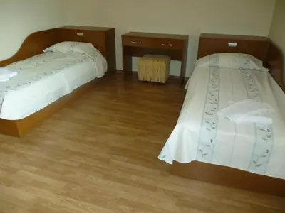 two beds in a hotel room with wooden floors at Апартамент в Лъки Пампорово комплекс in Pamporovo