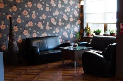 a living room with a leather couch and a table at Апартамент в Лъки Пампорово комплекс in Pamporovo