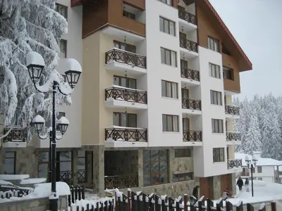 a hotel in the snow with snow covered trees at Апартамент в Лъки Пампорово комплекс in Pamporovo