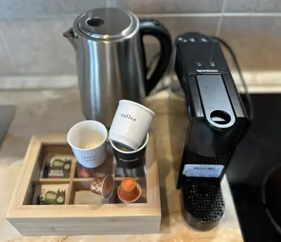 a coffeemaker and a coffee maker and cups on a counter at Villa Vista in Dolna Banya