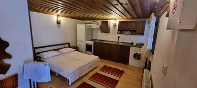 a small bedroom with a bed and a kitchen at Къща за гости Имало едно време in Smolyan
