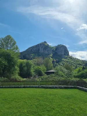 a fence in a field with a mountain in the background at Къща за гости Имало едно време in Smolyan