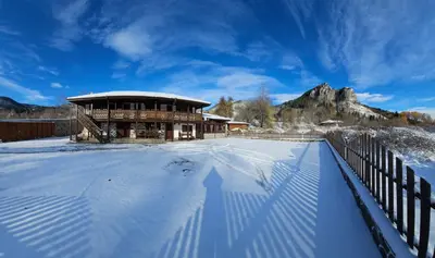 a building with a fence in the snow at Къща за гости Имало едно време in Smolyan