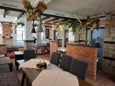 a restaurant with tables and chairs and a brick wall at Horlog Castle in Trigrad