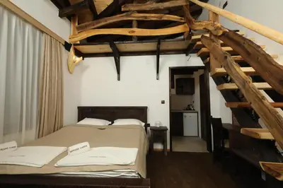 a bedroom with a large bed and a wooden staircase at Horlog Castle in Trigrad
