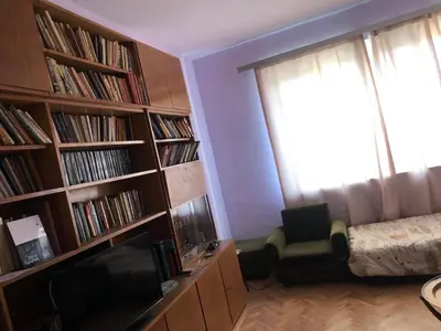 a room with book shelves with a bed and a window at City Flat Riverside Maritza in Plovdiv