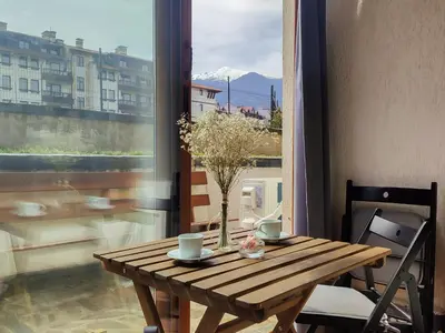 a wooden table with a vase on it next to a window at Deluxe Apartment In Belvedere With Terrace in Bansko