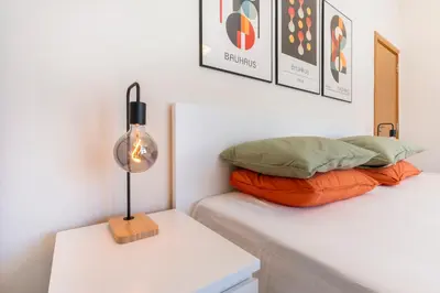 a bed with two pillows and a lamp on a table at The Architect Home - City Center, Free Parking! in Sofia