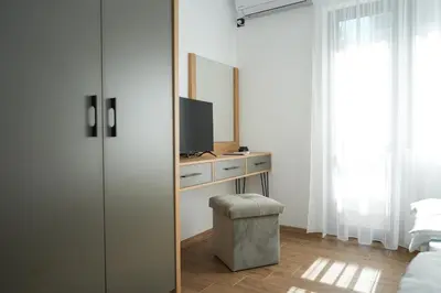 a bedroom with a dresser with a tv and a mirror at Sun City Apartment in Sandanski