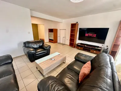 a living room with leather furniture and a flat screen tv at Central District 3 Bedroom Place in Plovdiv