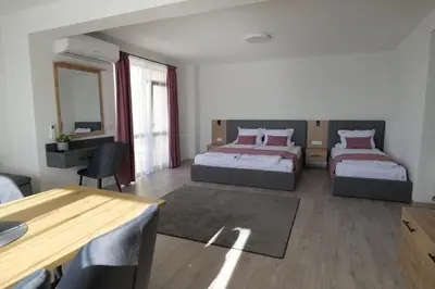 a bedroom with two beds and a desk and a table at Самуил къща за гости in Ognyanovo