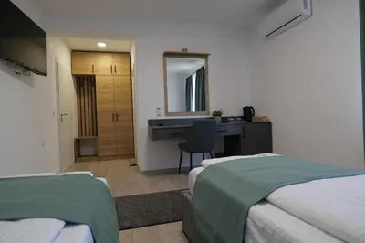 a bedroom with two beds and a desk and a mirror at Самуил къща за гости in Ognyanovo