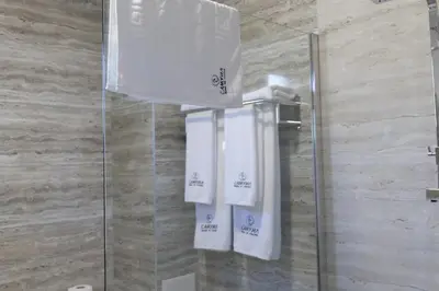two white towels are hanging in a shower at Самуил къща за гости in Ognyanovo