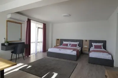 a bedroom with two beds and a desk and a table at Самуил къща за гости in Ognyanovo
