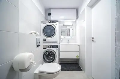 a bathroom with a washing machine and a toilet at My Campus 1 bdrm, Mountain view, Free parking, Self check-in in Sofia