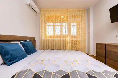 a bedroom with a large bed and a window at Bright and Cozy Apartment Next to a City Park by Flat Mаnager in Plovdiv