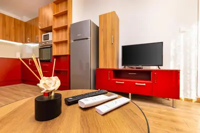 a kitchen with a table with remotes and a tv at Bright and Cozy Apartment Next to a City Park by Flat Mаnager in Plovdiv