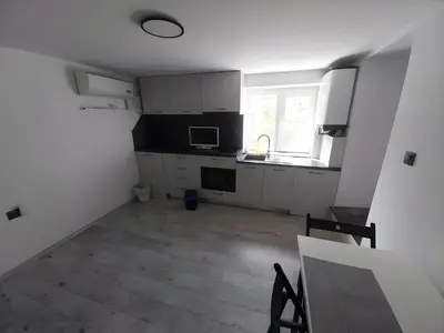 a kitchen with white cabinets and a wooden floor at Independent studio in a house in the city in Sofia
